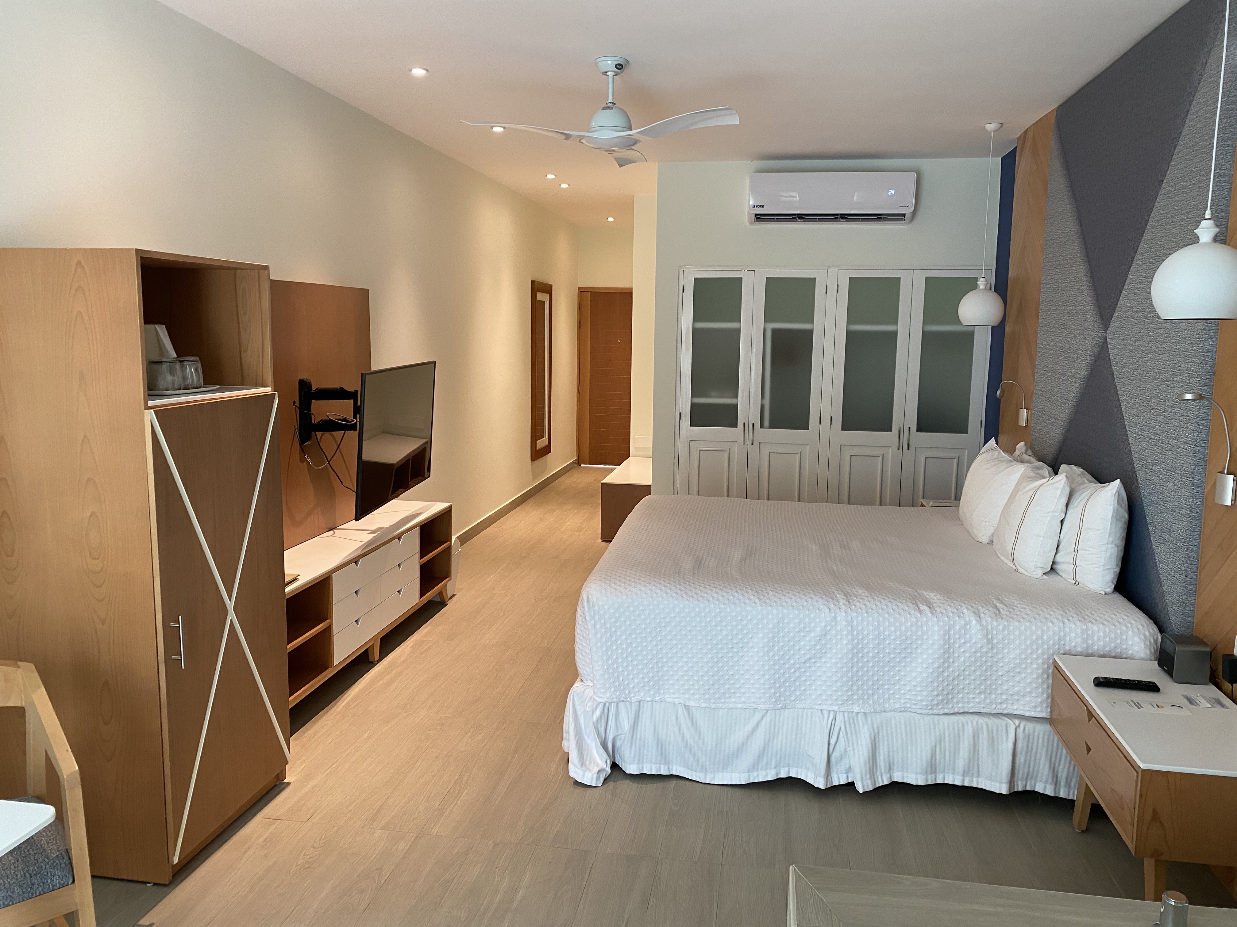 Jacuzzis al aire libre en terraza de hotel con piso de madera y decoración de plantas